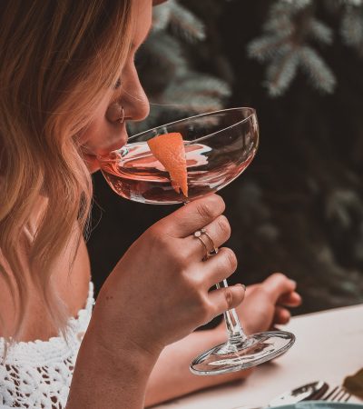 Beautiful young woman sipping cocktail